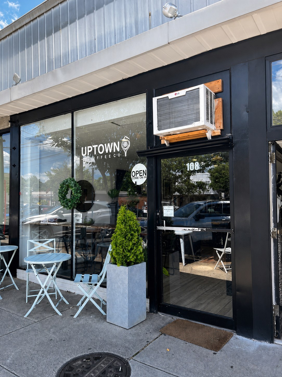 Uptown Coffee Co. storefront at 108 W Pleasant Ave with outdoor tables and planters